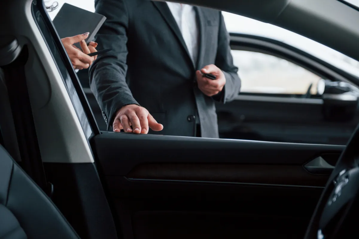 Un passager en costume monte à l’arrière d’une voiture